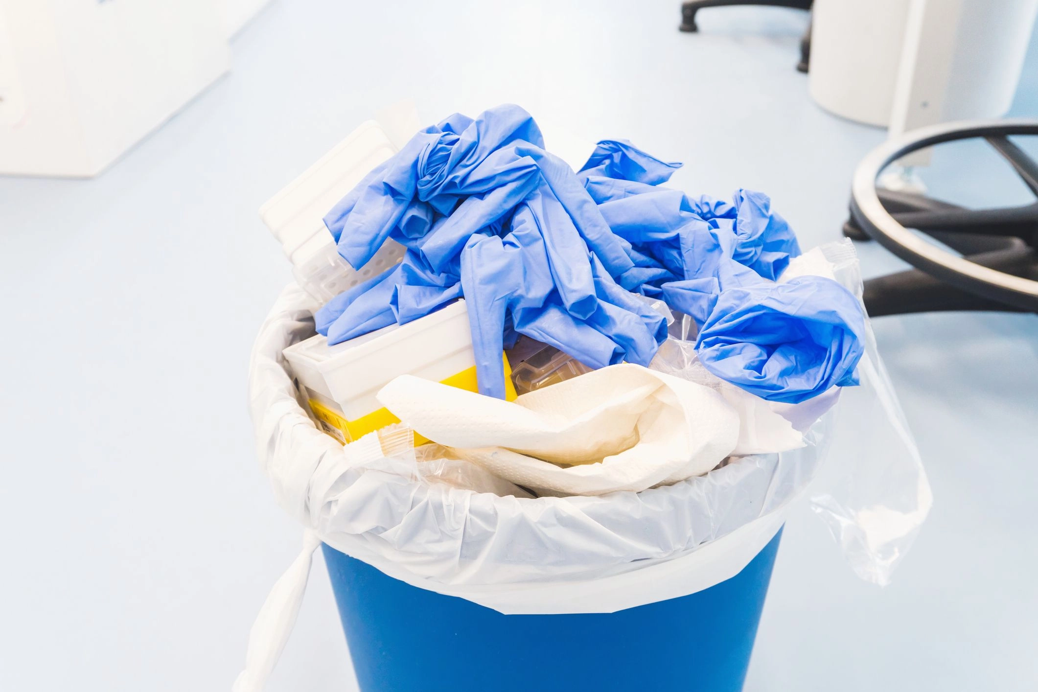image of a laboratory waste managment bin with assoted bloves and plastics