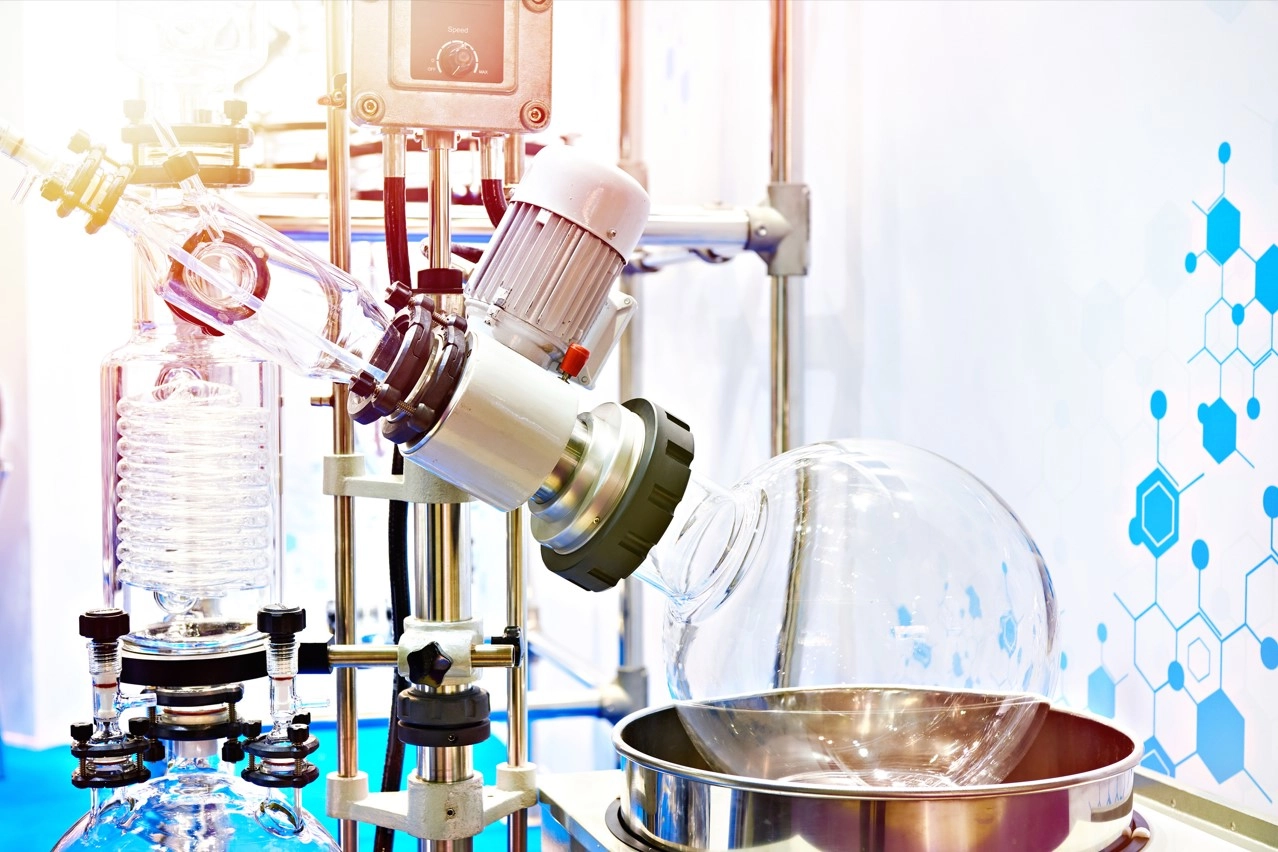 Image of a rotary evaporator in a modern lab. Instrument shows rotating flask in heating bath with vertical condenser