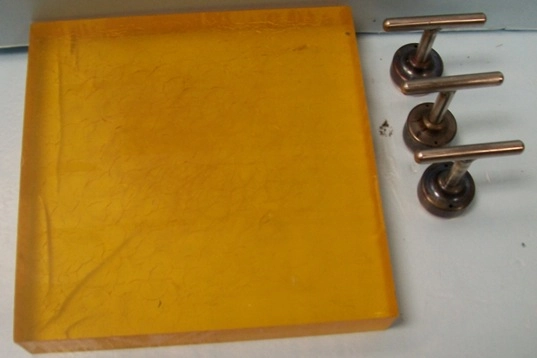 12"X 12" X 2" AMBER PUNCH OR POUNDING BLOCK / BOARD WITH 3 PUNCHES 2 @ 2" DIA 1 @ 1-3/4" FOR LEATHE