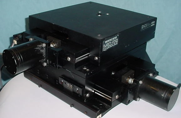 DCI 2 axis positioning stage, DC-66R, 6"x6",&nbsp; cross roller bearing, 5 pitch Acme, Compumotor stepper motors and CX microstep drives, RS232, precision . Dimensions: 10 x 10 x 6" high plus NEMA 21 motors. 57 pound total weight.