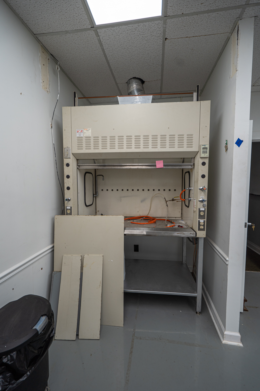 Fume Hood approx 5 ft wide with door and fume exhaust fan. Includes the table it is sitting on.